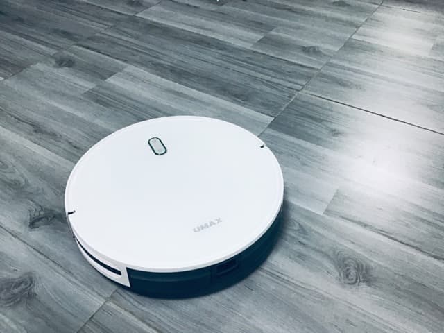 Gri zeminde beyaz robot süpürge